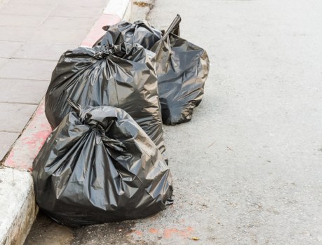 Workers preparing an office clearance with protective gear and labeled waste bags